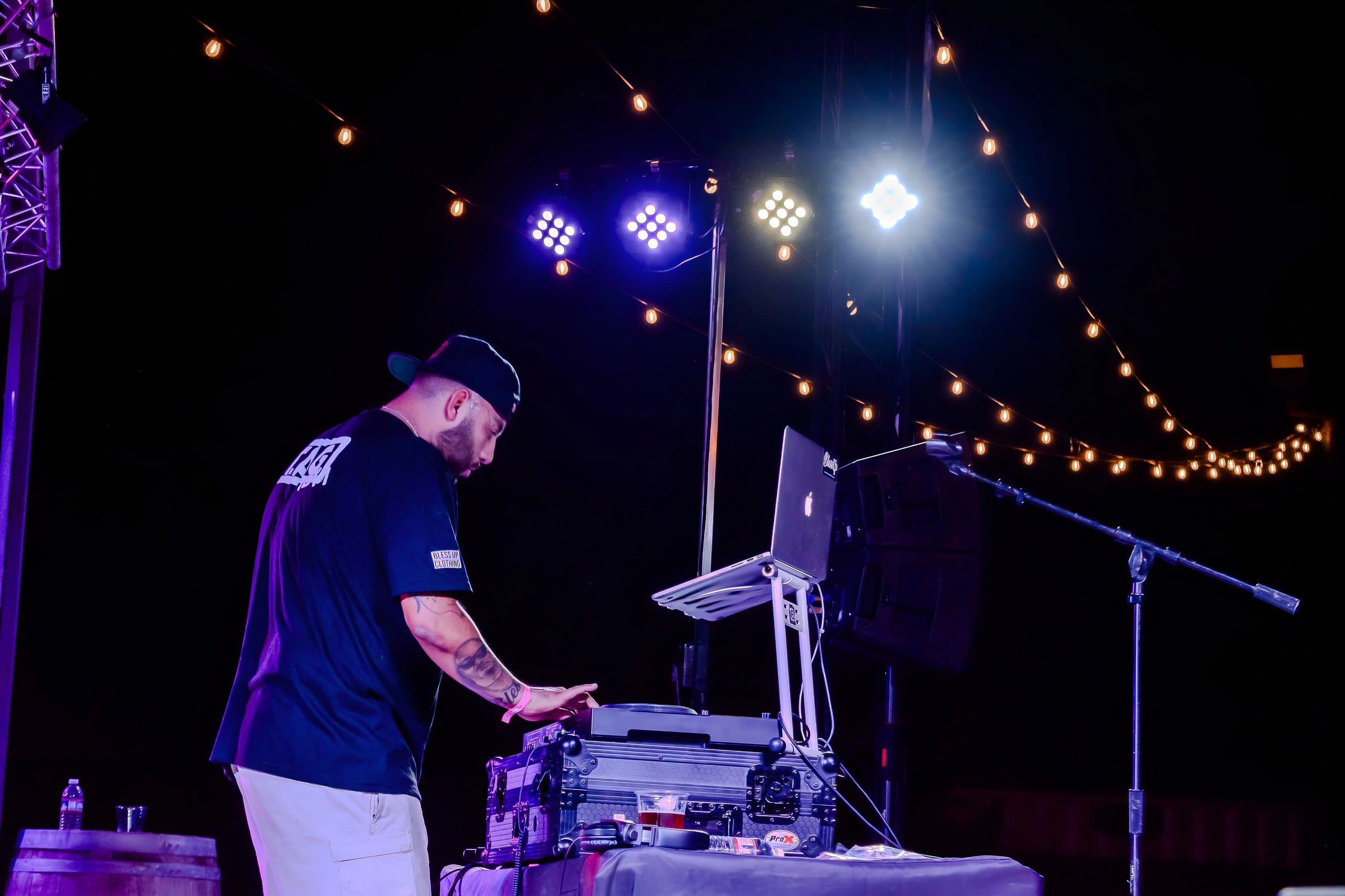 DJ T.A.G. performing under string lights